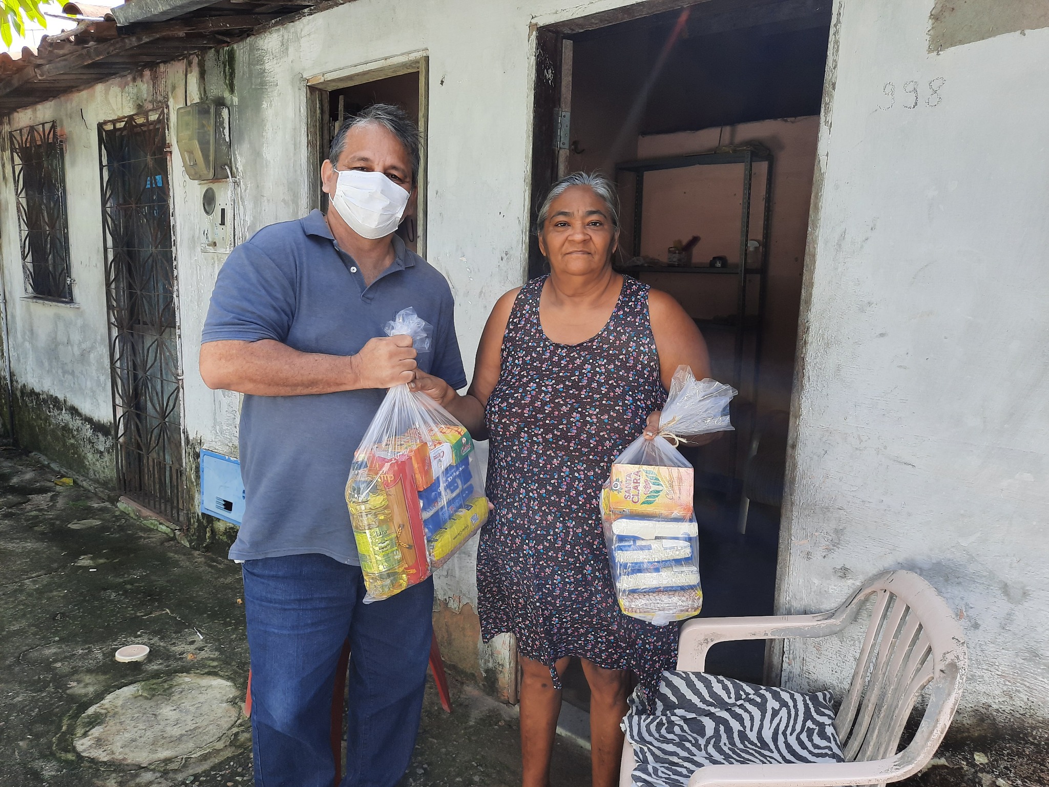 Beneficiária recebendo uma cesta de alimentos