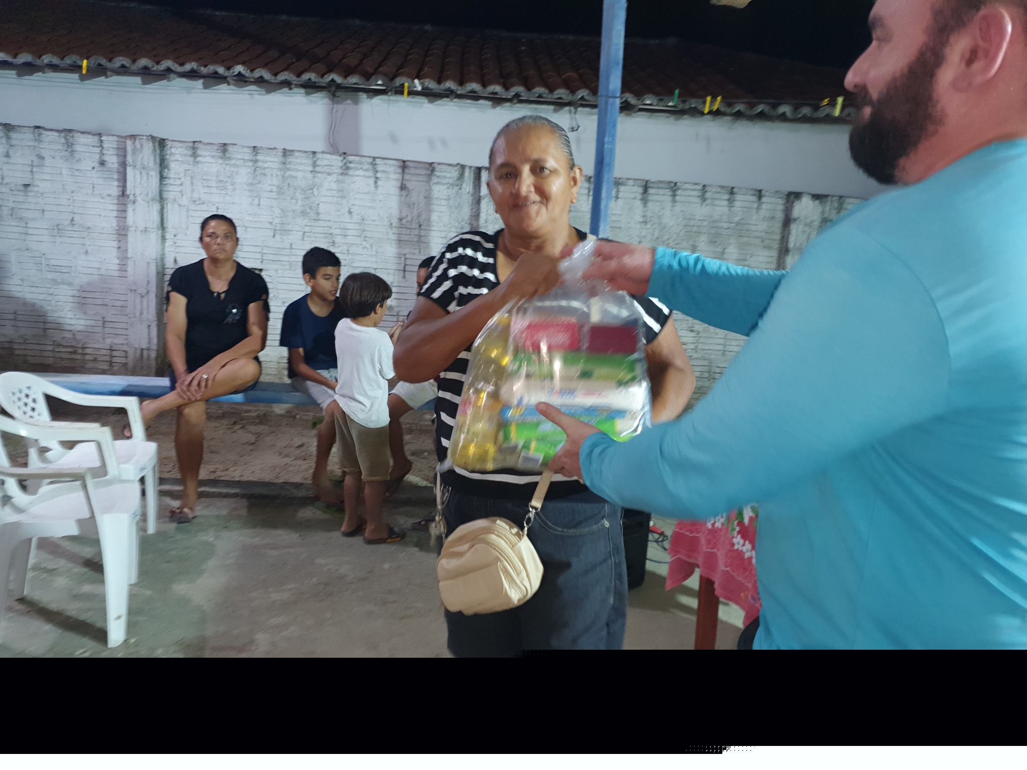 Beneficiária recebendo alimentos na sede
